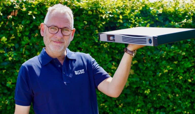 Intersonic Sales Manager Denmark, Søren Holstebro holding an APEX CloudPower amplifier